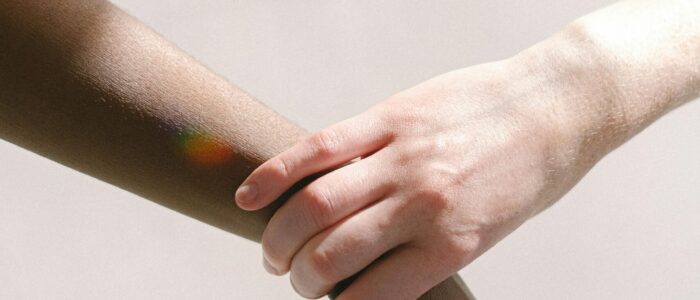 Close-up of diverse hands clasped together, symbolizing unity and support.