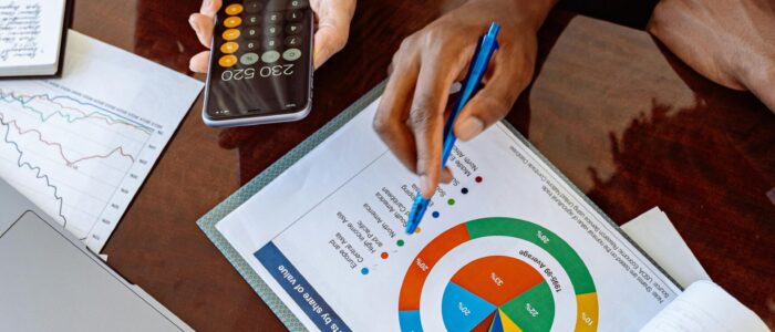 Two business professionals discussing financial documents and strategies at an office desk.